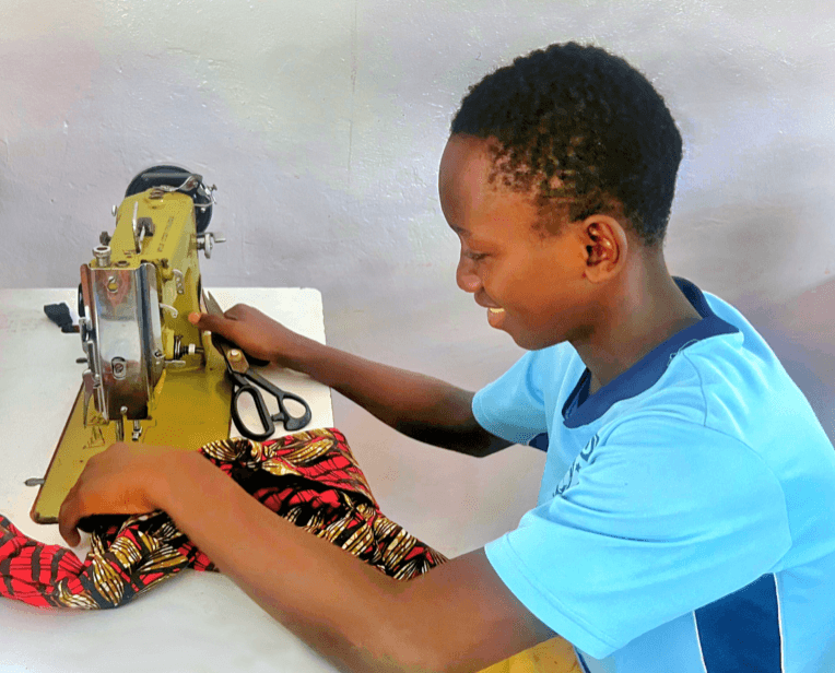 Un jeune apprend la couture sur une machine à coudre